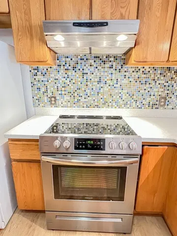 a view of an empty room with window and fire place