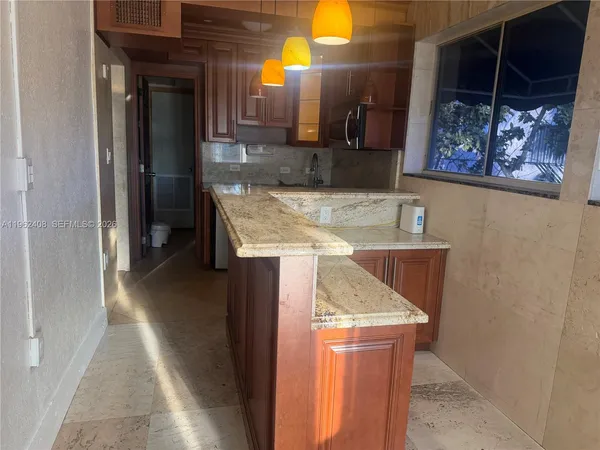a kitchen with granite countertop a sink and a stove