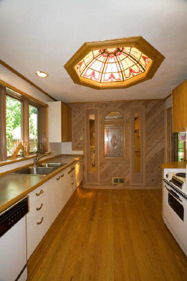 4808 Spring Creek Road Rockford, IL 61114 - Photo 5 of 6 a large kitchen with kitchen island a stove a sink and a large window with wooden floor