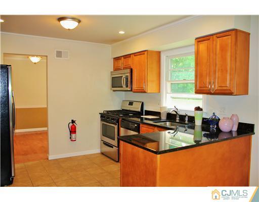 26 Ridge Road Edison, NJ 08817 - Photo 6 of 23 a kitchen with granite countertop a sink cabinets and window
