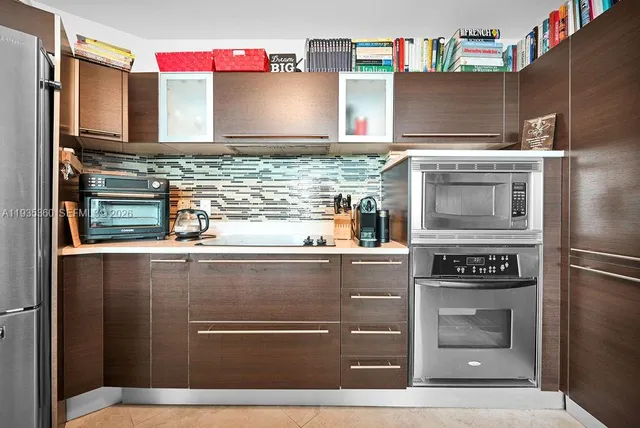 a kitchen with stainless steel appliances granite countertop a refrigerator a stove a sink and a refrigerator