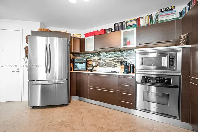 a open kitchen with stainless steel appliances kitchen island granite countertop a table and chairs in it