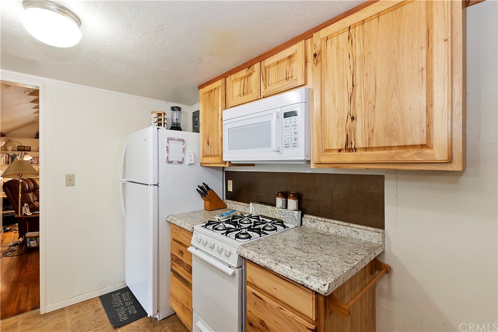 1211 Bridal Path Rimforest, CA 92378 - Photo 15 of 28 a kitchen with stainless steel appliances granite countertop a refrigerator and a stove