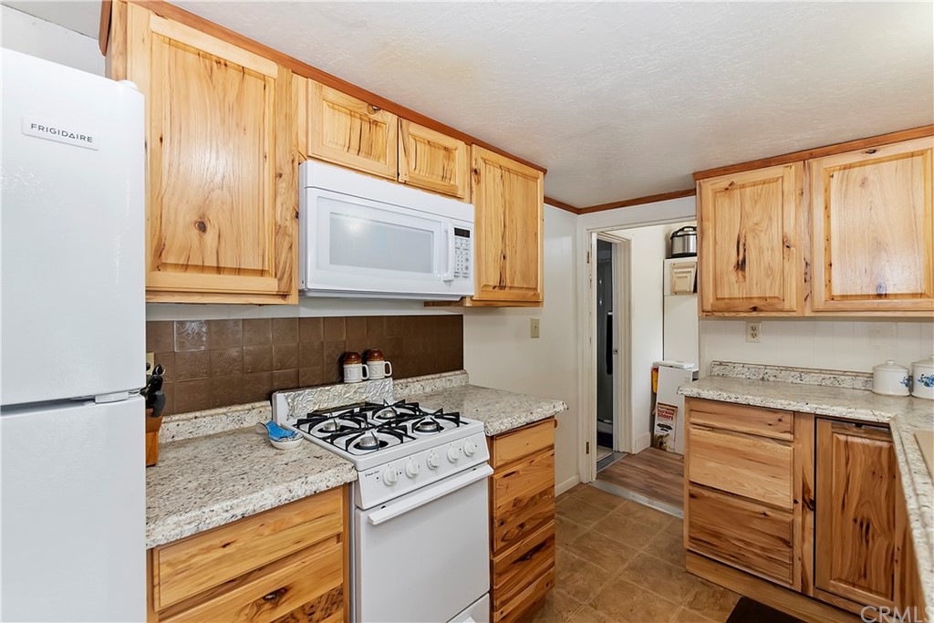1211 Bridal Path Rimforest, CA 92378 - Photo 4 of 28 a kitchen with a stove a refrigerator and cabinets
