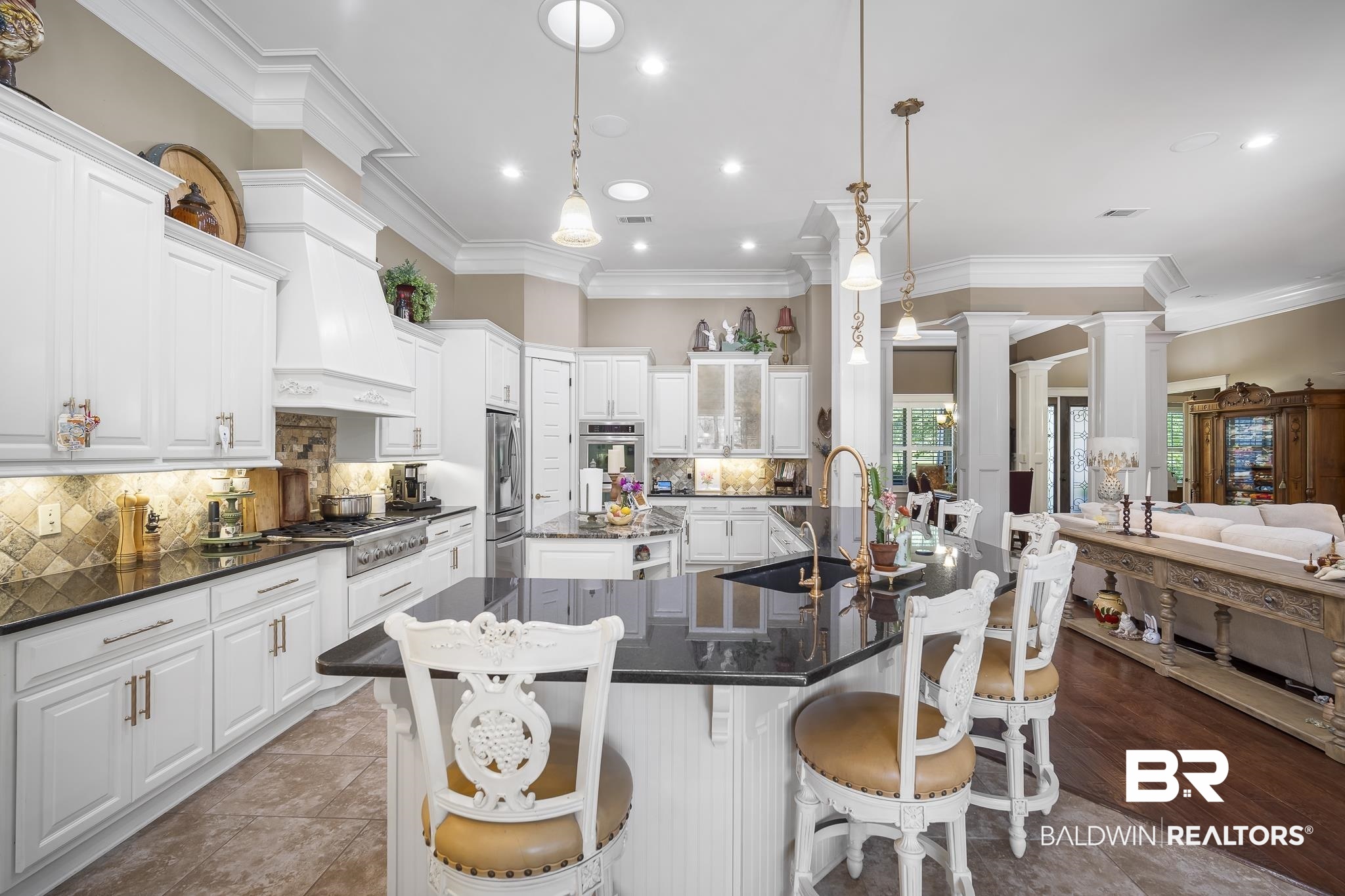 25212 Austin Road Daphne, AL 36526 - Photo 21 of 56 Kitchen with dark stone countertops, decorative light fixtures, a breakfast bar, crown molding, and decorative backsplash