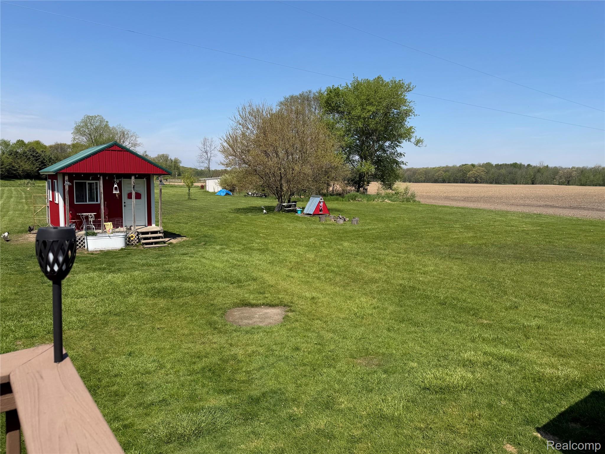 6860 Grand River Road Bancroft, MI 48414 - Photo 24 of 31 View of green lawn featuring an outdoor structure, a view of rural / pastoral area, and covered porch