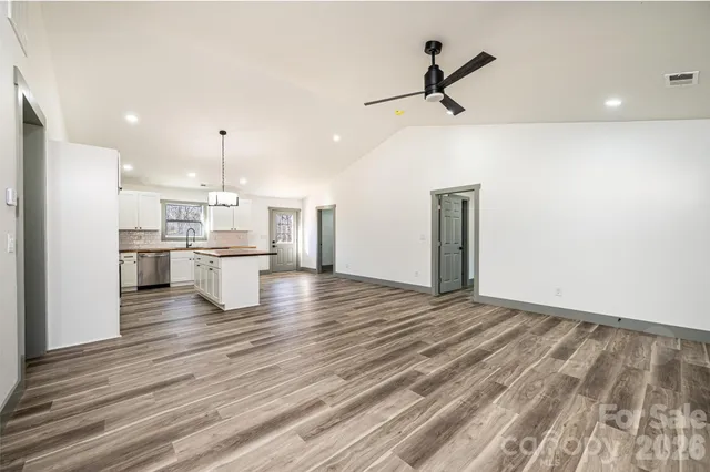 an empty room with wooden floor and ceiling fan