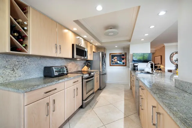 a large kitchen with stainless steel appliances granite countertop a sink dishwasher stove and oven