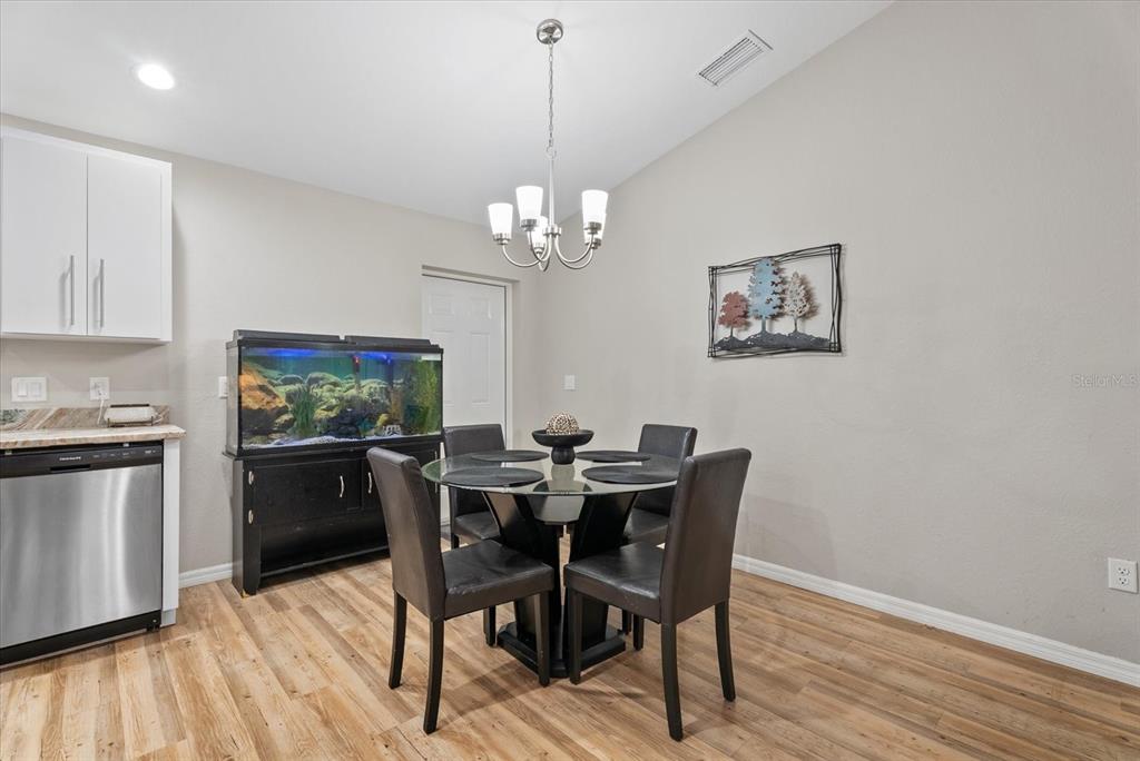 8288 Southwest Sunnybreeze Road Arcadia, FL 34269 - Photo 8 of 18 a view of a dining room with furniture wooden floor and chandelier