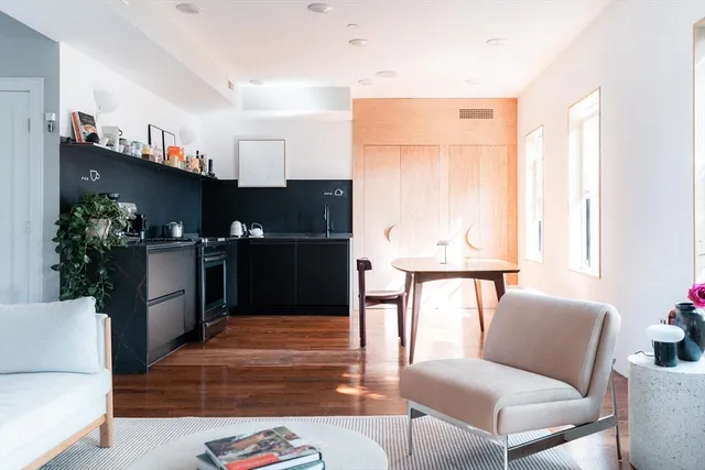 a living room with furniture a window and a potted plant