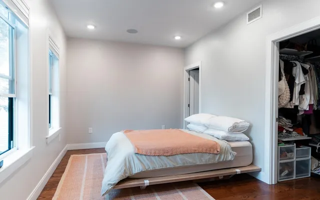 a bedroom with a bed and wooden floor