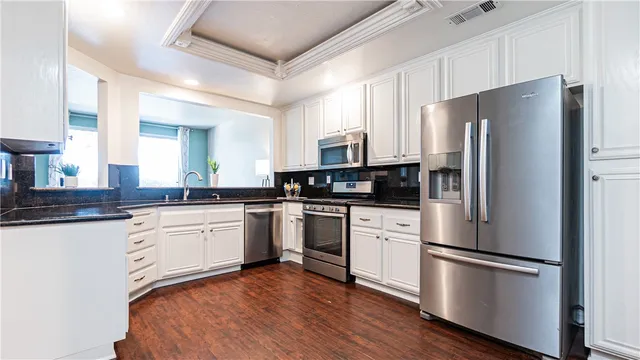 a kitchen with stainless steel appliances a refrigerator sink and microwave