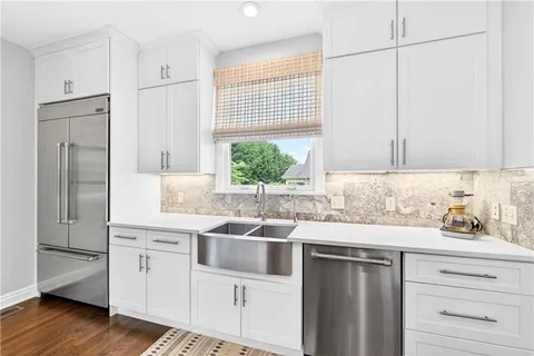 a kitchen with stainless steel appliances white cabinets and a window