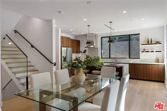a living room with furniture kitchen view and a wooden floor