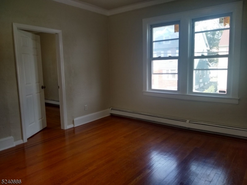 326 Field Place, Unit 2L Hillside, NJ 07205 - Photo 13 of 17 an empty room with wooden floor and windows