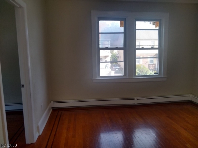 326 Field Place, Unit 2L Hillside, NJ 07205 - Photo 14 of 17 an empty room with wooden floor and windows