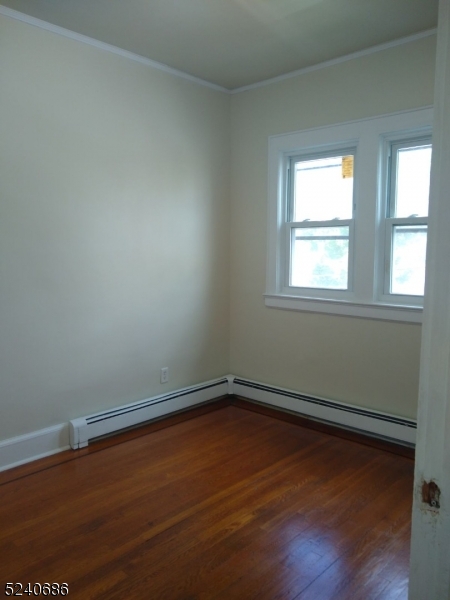 326 Field Place, Unit 2L Hillside, NJ 07205 - Photo 17 of 17 an empty room with wooden floor and windows