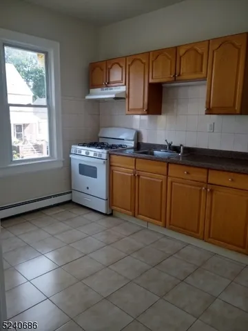 a kitchen with stainless steel appliances granite countertop a sink stove and cabinets