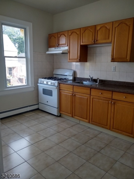 326 Field Place, Unit 2L Hillside, NJ 07205 - Photo 4 of 17 a kitchen with stainless steel appliances granite countertop a sink stove and cabinets
