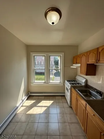 a kitchen with granite countertop a stove a sink and a granite counter top