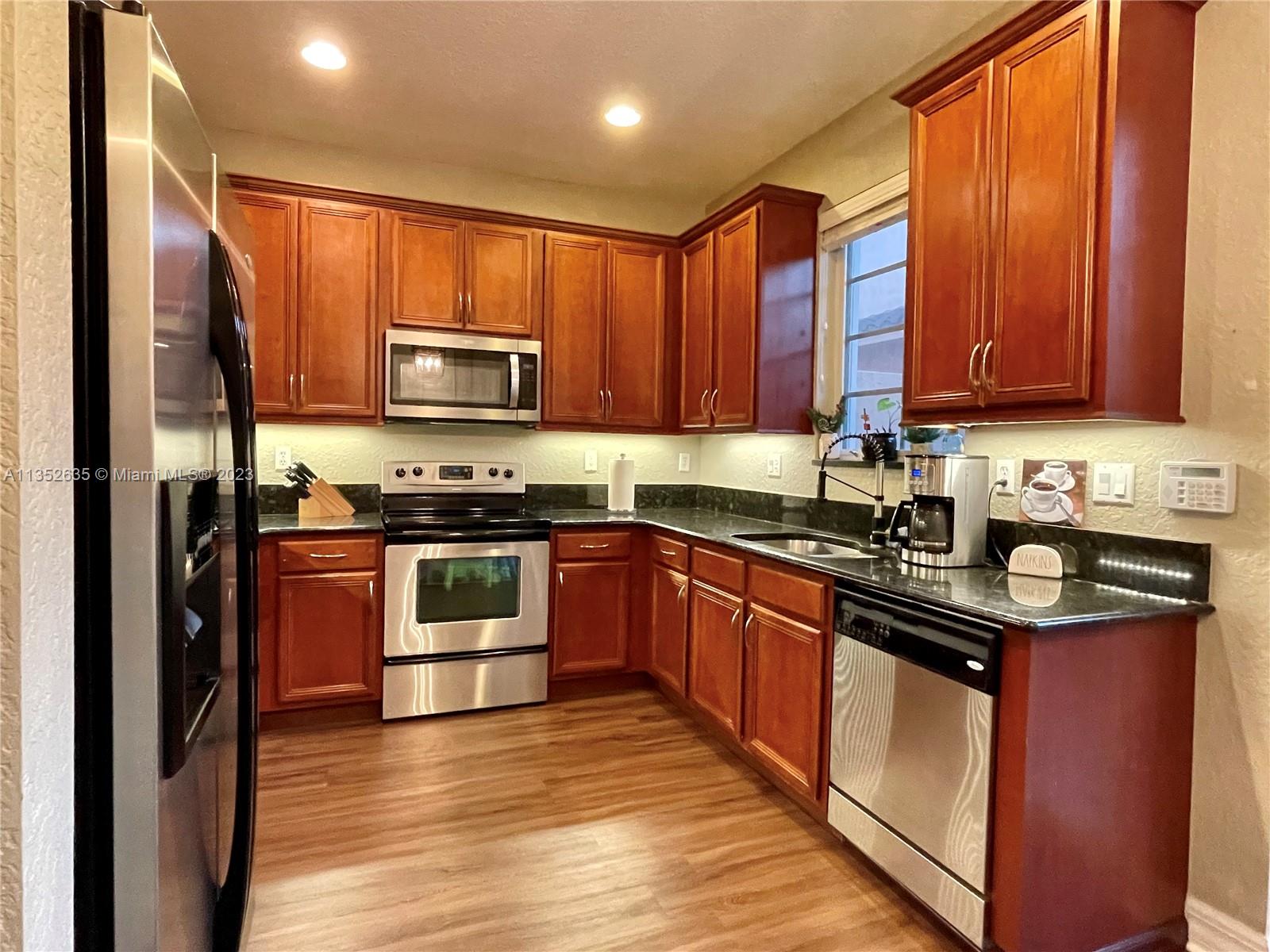 128 Midleton Way Jupiter, FL 33458 - Photo 13 of 39 a kitchen with stainless steel appliances granite countertop a stove a sink and a microwave