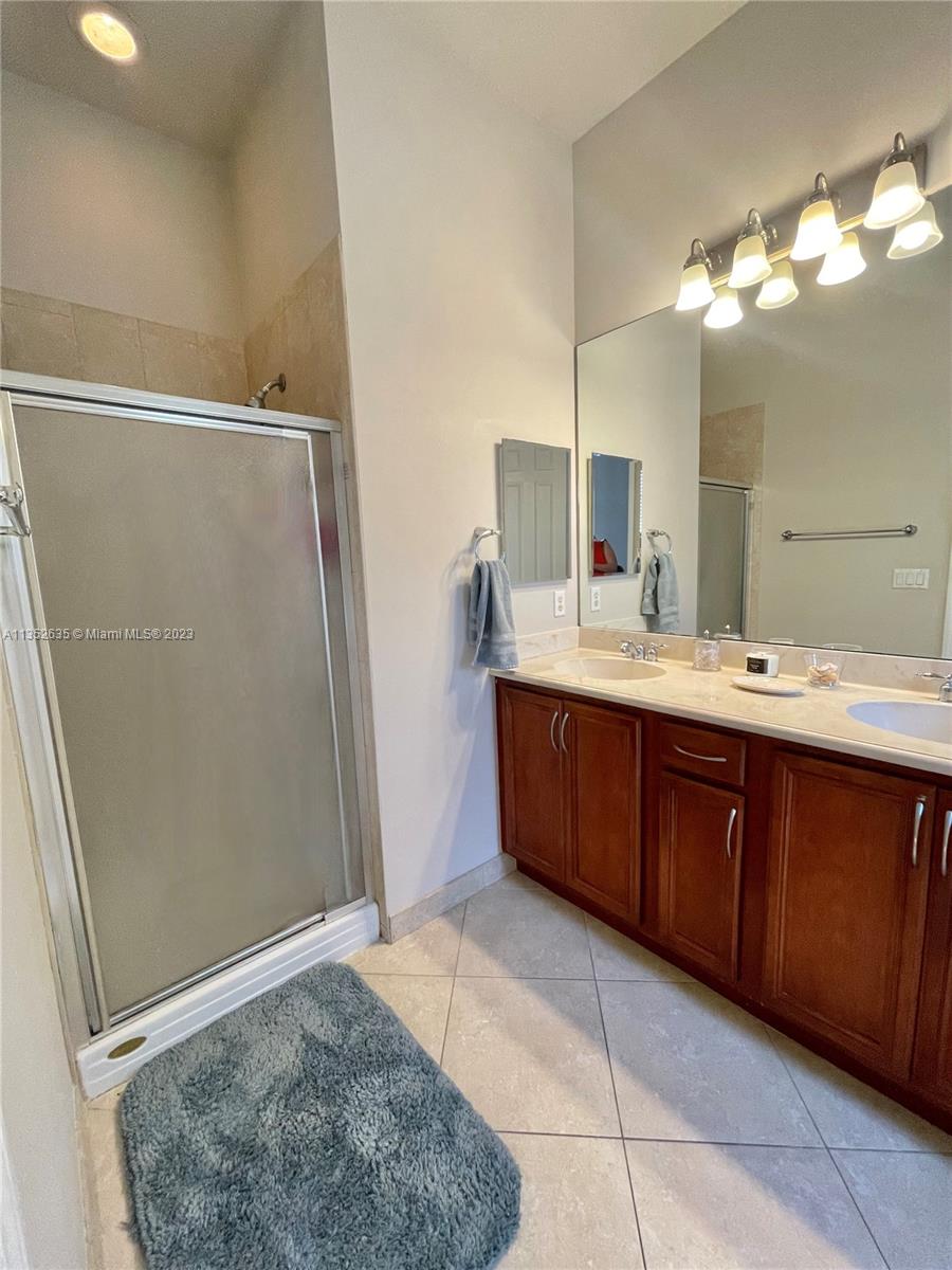 128 Midleton Way Jupiter, FL 33458 - Photo 31 of 39 a bathroom with a double vanity sink a mirror and a shower