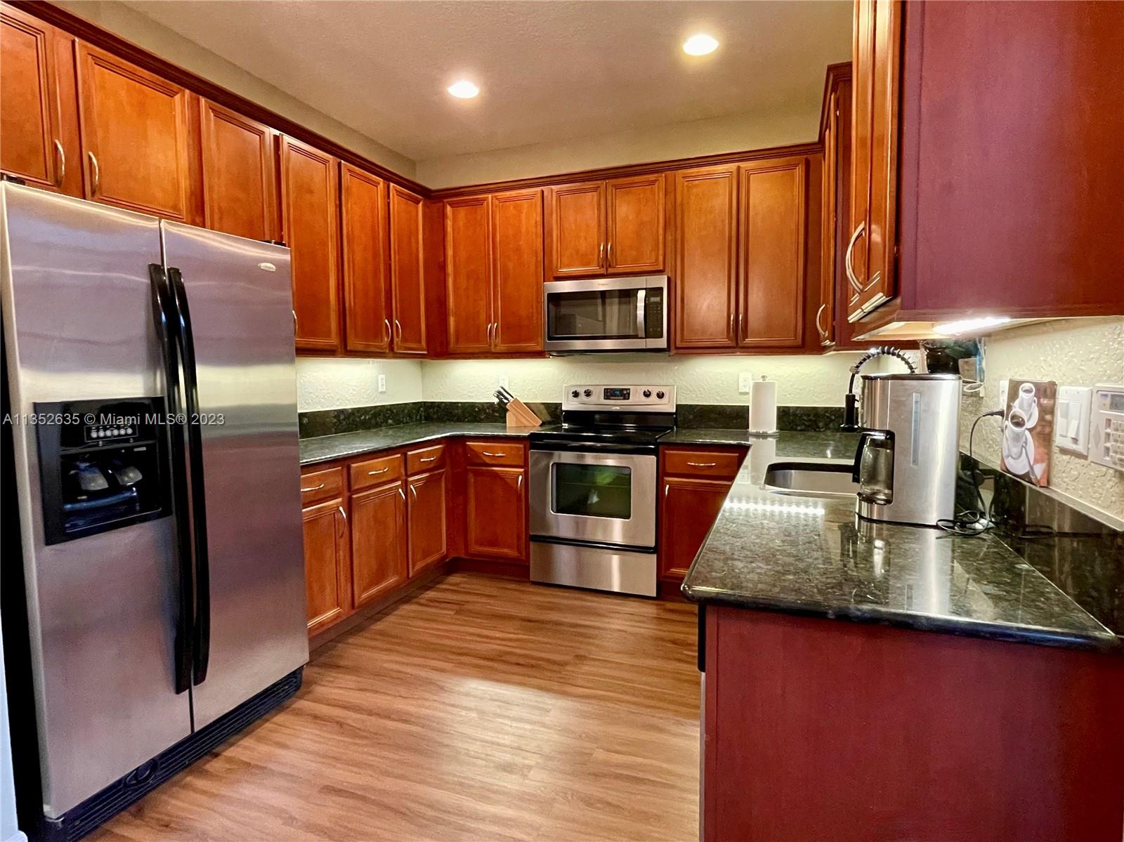 128 Midleton Way Jupiter, FL 33458 - Photo 8 of 39 a kitchen with stainless steel appliances granite countertop wooden cabinets a stove top oven a sink and dishwasher