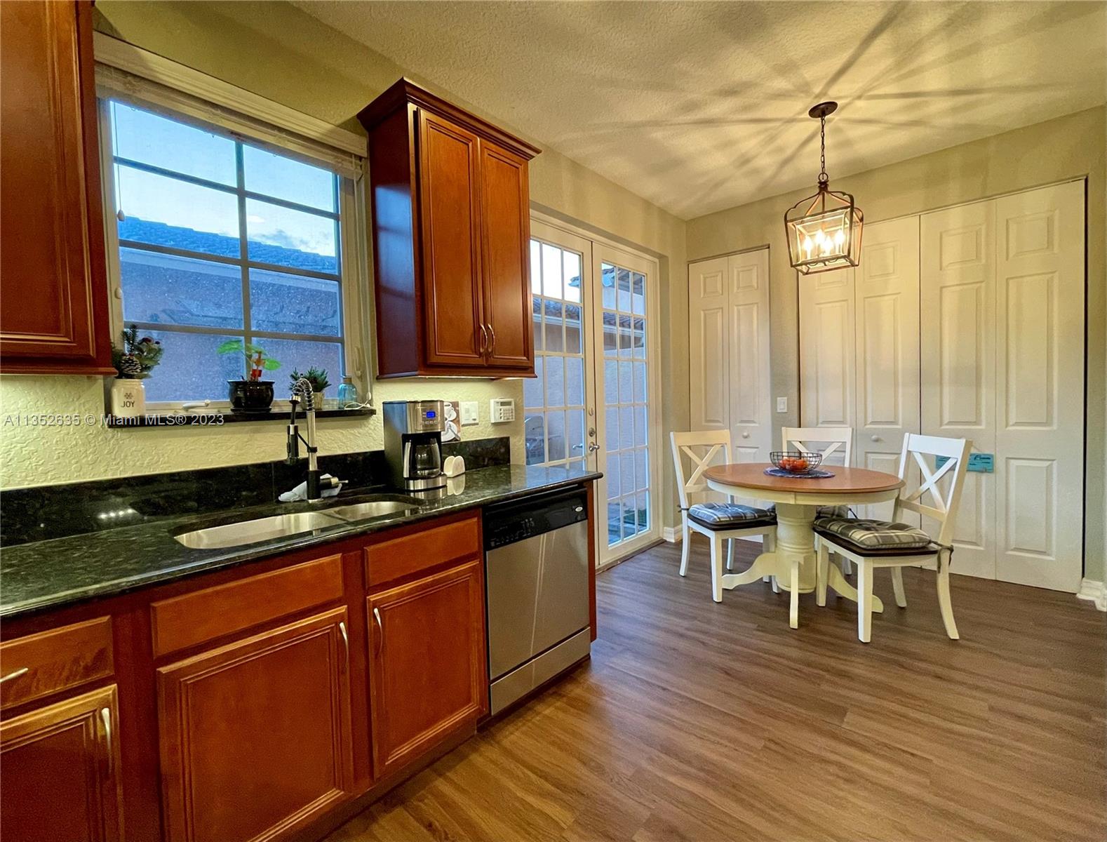 128 Midleton Way Jupiter, FL 33458 - Photo 9 of 39 a kitchen with stainless steel appliances granite countertop wooden floors sink and cabinets