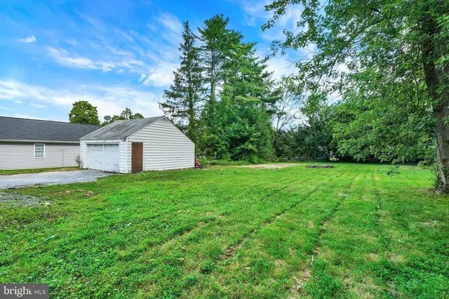 an aerial view of residential houses with outdoor space and trees