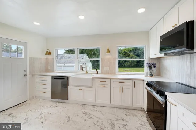 a kitchen with granite countertop a sink stainless steel appliances and cabinets