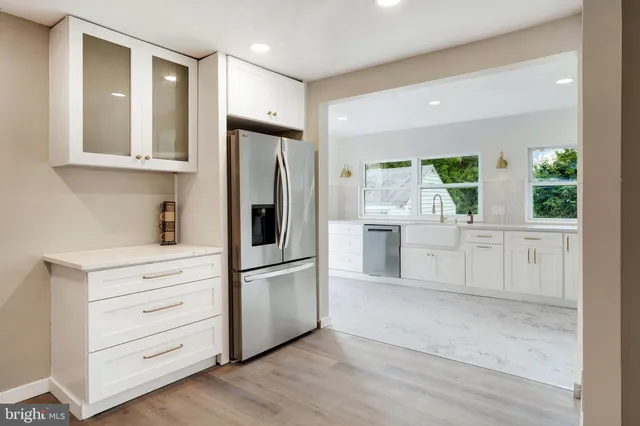 a kitchen with white cabinets and a refrigerator
