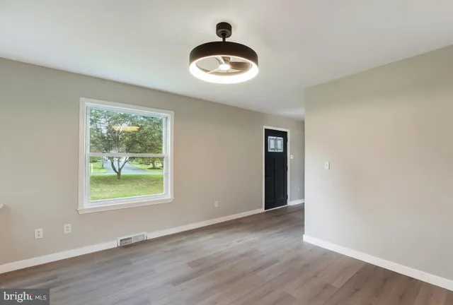 an empty room with wooden floor and a window