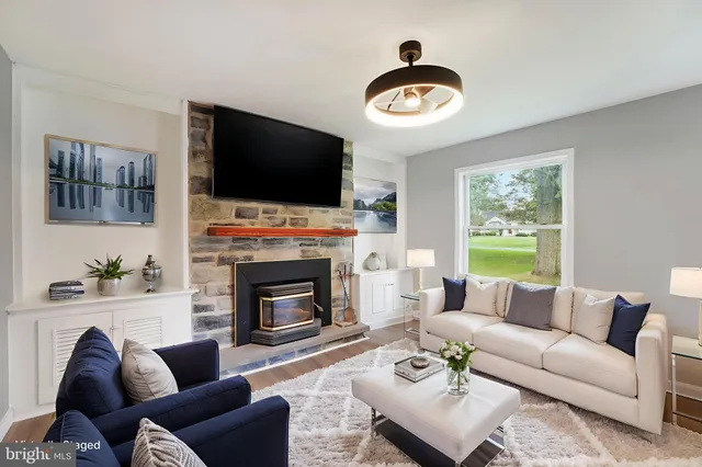 a view of an empty room with wooden floor fireplace and a window