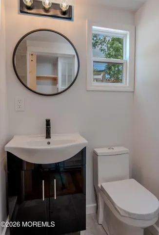 a bathroom with a toilet a sink and mirror
