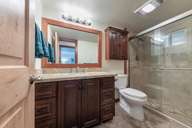 a bathroom with a granite countertop sink toilet and shower