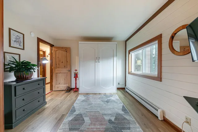 a view of an entryway with wooden floor and cabinet