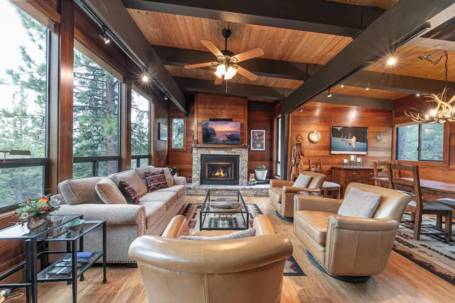 a living room with furniture a fireplace and a large window