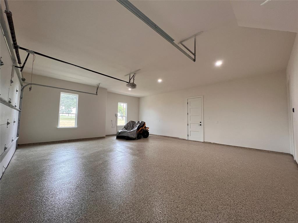 121 Cartwright Park Road Weatherford, TX 76087 - Photo 4 of 17 Spacious garage featuring a speckled epoxy floor, recessed lighting, and white interior walls