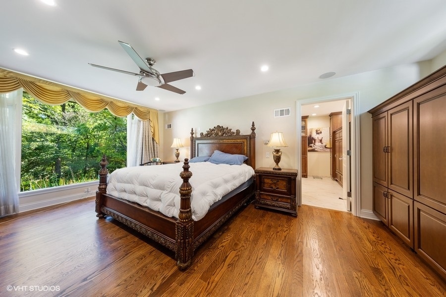 6547 South County Line Road Burr Ridge, IL 60527 - Photo 12 of 24 a spacious bedroom with a bed and a large window