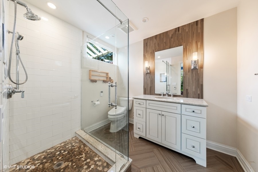 6547 South County Line Road Burr Ridge, IL 60527 - Photo 10 of 24 a spacious bathroom with a granite countertop sink a toilet and a mirror