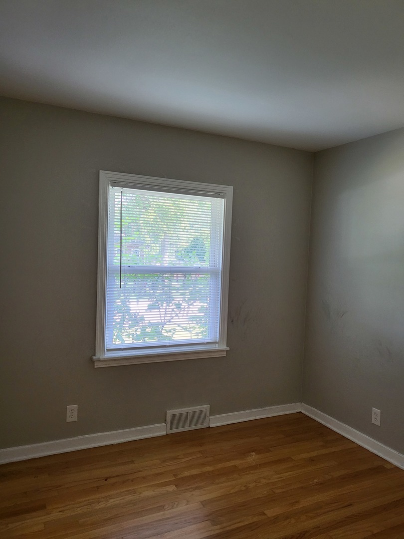 3328 Butler Avenue Steger, IL 60475 - Photo 11 of 22 an empty room with wooden floor and windows