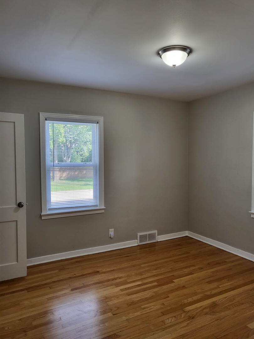 3328 Butler Avenue Steger, IL 60475 - Photo 14 of 22 a view of an empty room with wooden floor and a window