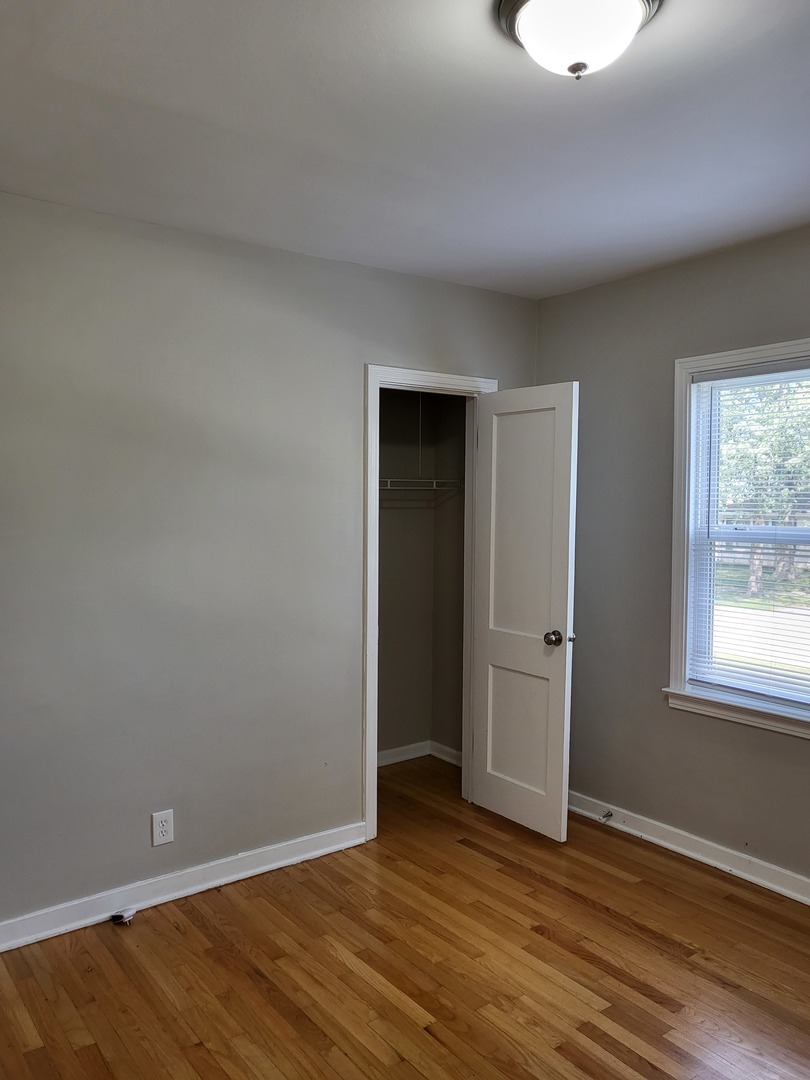 3328 Butler Avenue Steger, IL 60475 - Photo 16 of 22 a view of an empty room with wooden floor and a window