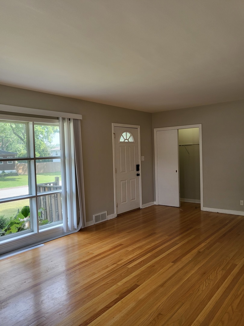 3328 Butler Avenue Steger, IL 60475 - Photo 8 of 22 an empty room with wooden floor and windows