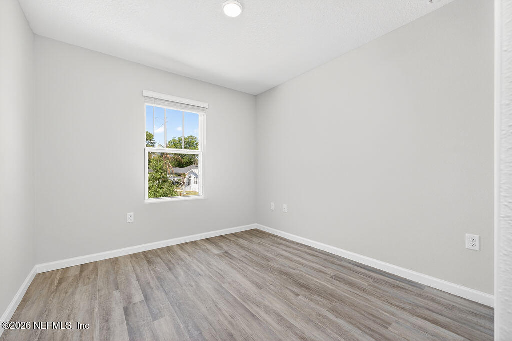 857 Jackson Road Jacksonville, FL 32225 - Photo 25 of 29 an empty room with wooden floor and windows