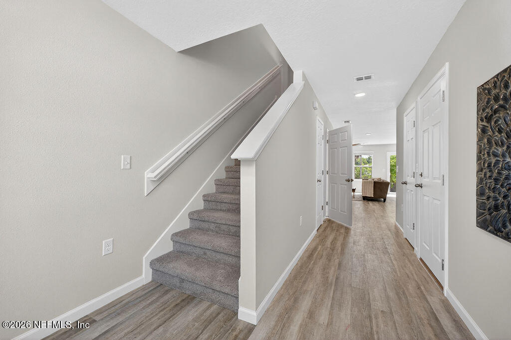 857 Jackson Road Jacksonville, FL 32225 - Photo 7 of 29 a view of a hallway with wooden floor and staircase