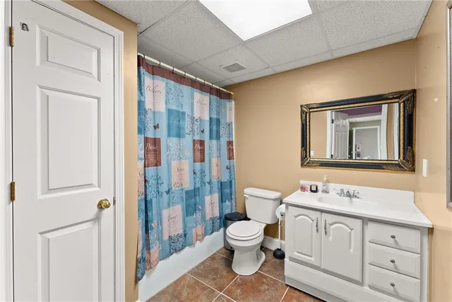 a view of a house with a big yard plants and large trees