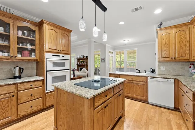 a kitchen with stainless steel appliances granite countertop a sink a stove and a refrigerator