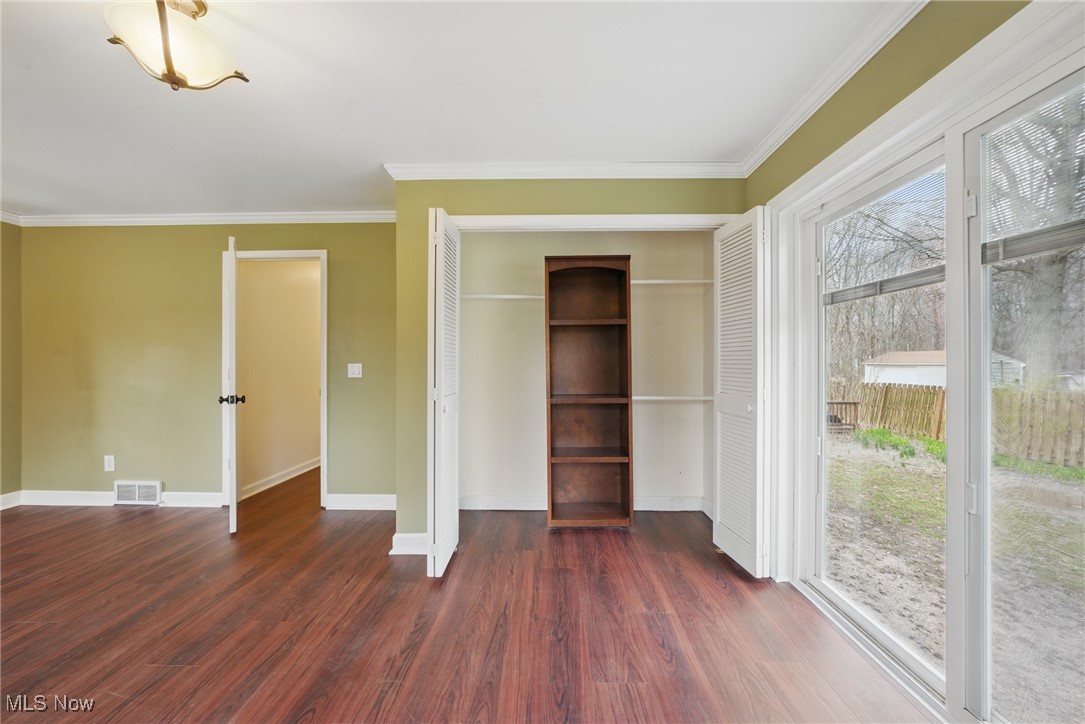 28575 White Road Wickliffe, OH 44092 - Photo 20 of 49 Unfurnished bedroom featuring visible vents, access to outside, ornamental molding, and dark wood-style floors