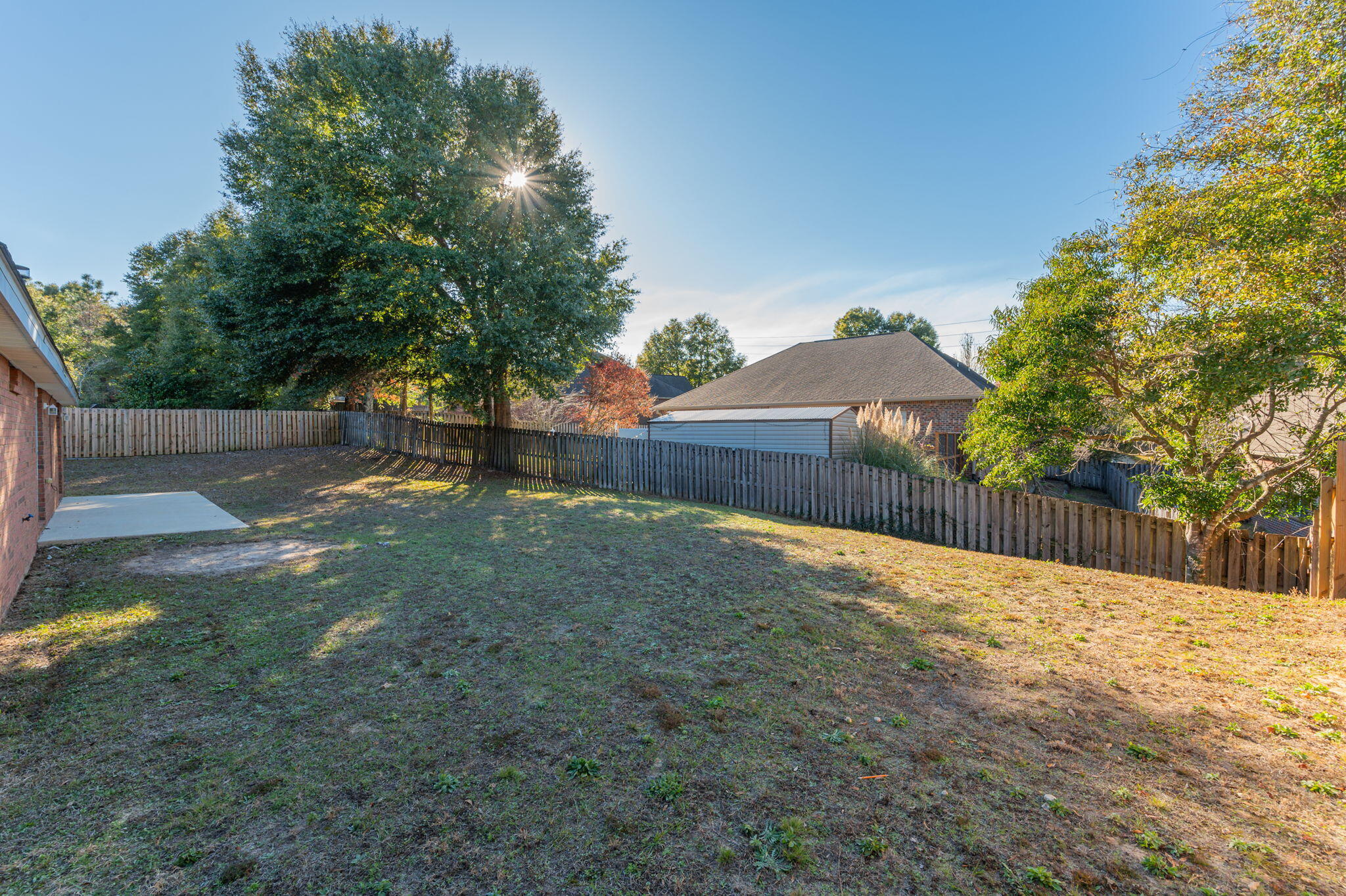 546 Tikell Drive Crestview, FL 32536 - Photo 20 of 20 a backyard of a house with wooden fence and large trees